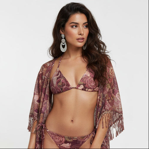 Four women modeling matching bohemian-style bikini sets in a 2x2 grid against a light gray studio background. The bikinis feature a dusty mauve and burgundy paisley pattern, with one model wearing a wide-brim brown hat and another wearing a matching sheer fringed cover-up.