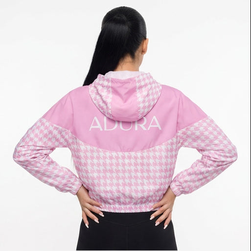 Pink checkered hoodie with 'ADCRA' branding worn by a model on a white background