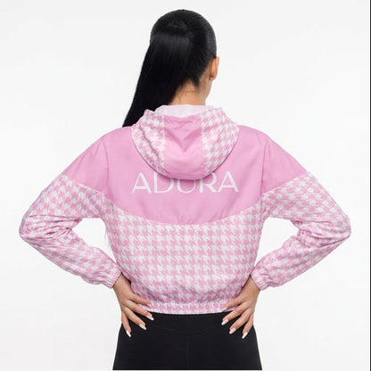 Pink checkered hoodie with 'ADCRA' branding worn by a model on a white background