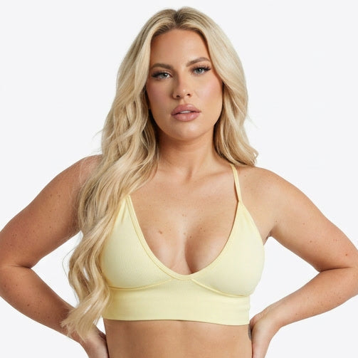 Four women wearing different colored sports bras on a white background