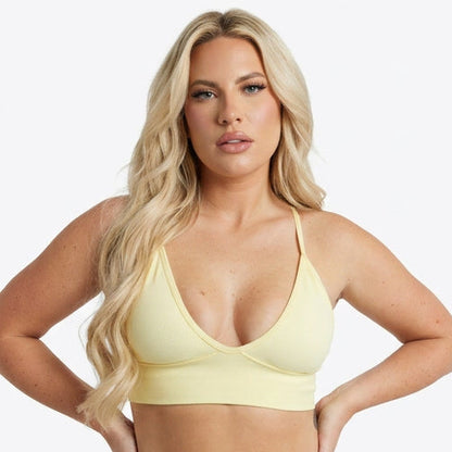 Four women wearing different colored sports bras on a white background
